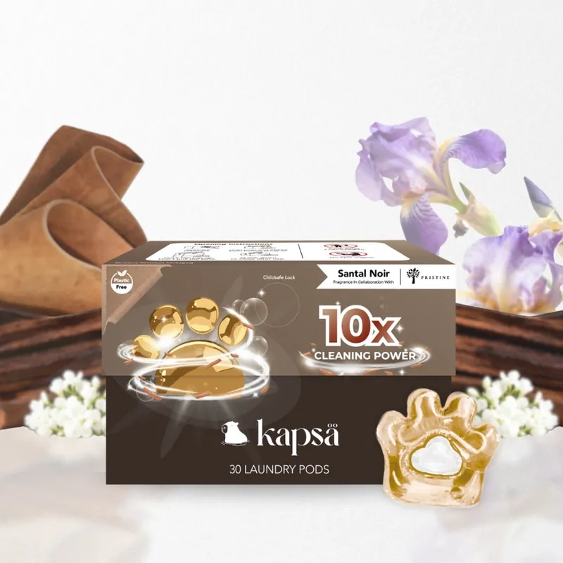 A box of Kapsä Santal Noir laundry pods with an amber paw-shaped pod